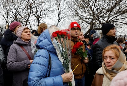 Ciudadanos rusos sujetan claveles en el exterior de la iglesia ortodoxa para despedir al opositor ruso Alexéi Navalni. 