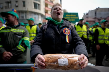 A woman holds a loaf of bread during a farmers' protest in front of the Representative Office of the European Commission in Bucharest, Romania, on, April 7, 2023.
