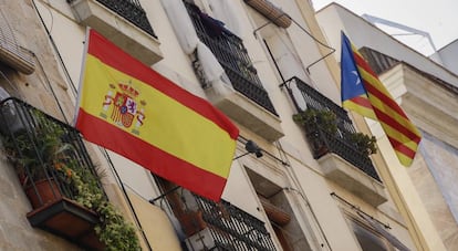 Bandera espa&ntilde;ola y bandera catalana estelada independentista en un edificio de Barcelona