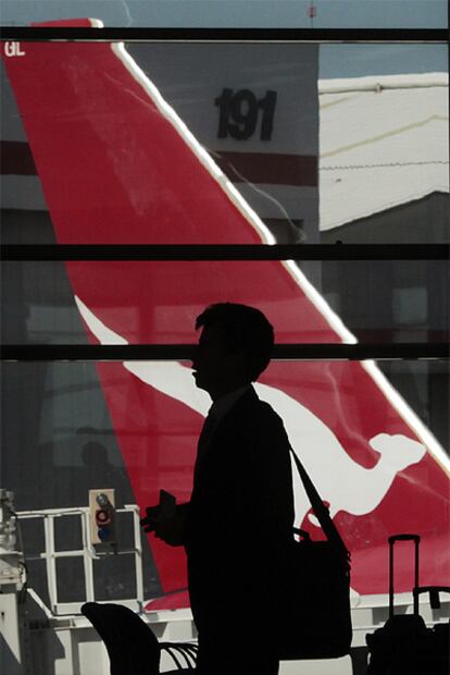 Un pasajero espera en el aeropuerto de Sydney, frente a la terminal en la que opera Qantas.