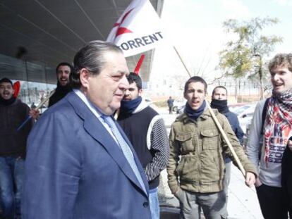 Vicente Boluda sale de la Universidad Jaume I de Castell&oacute;n, rodeado de estudiantes que protestan contra los recortes.