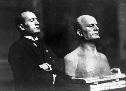 Mussolini, junto a un busto en su honor, en 1925.