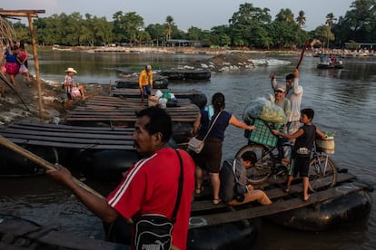 Un grupo de personas cruzan el río Suchiate.