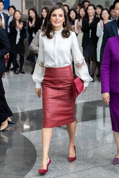 Los reyes también visitaron este año Corea del Sur. En uno de los actos, doña Letizia optó por una falda lápiz de cuero rojo de Hugo Boss, que combinó con una camisa blanca de mangas abullonadas y cuello mao. Meghan Markle, duquesa de Sussex, lució la misma falda al día siguiente, pero apostó por el monocroma en su conjunto, con un jersey de pico y unos tacones de aguja en granate.