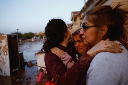 Eva Defez, de 50 años, es abrazada por unas amigas en el exterior de su vivienda en Utriel (Valencia).