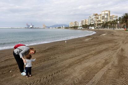 Uma mulher com o filho na praia da Malagueta, em Málaga.