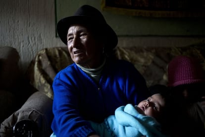 Una partera coge en sus brazos a un bebé al que ha ayudado a dar a luz.