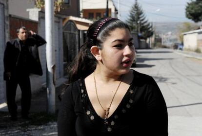 Leonarda Dibrani, the 15-year-old schoolgirl whose deportation from France sparked a huge outcry, speaks to the media as her father Resat talks on his cellphone outside their temporary home in Mitrovica.