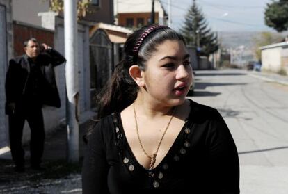 Leonarda Dibrani, the 15-year-old schoolgirl whose deportation from France sparked a huge outcry, speaks to the media as her father Resat talks on his cellphone outside their temporary home in Mitrovica. 