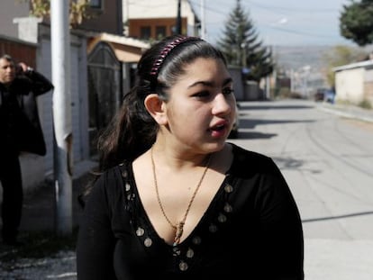 Leonarda Dibrani, the 15-year-old schoolgirl whose deportation from France sparked a huge outcry, speaks to the media as her father Resat talks on his cellphone outside their temporary home in Mitrovica. 