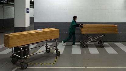 Una trabajadora de la funeraria Mémora traslada féretros con los restos mortales de víctimas de covid en el Tanatorio de Sancho de Ávila de Barcelona, este lunes.