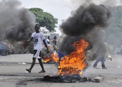 Partidarios de Alassane Ouattara montan una barricada en una calle de Abiyán.