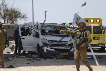 Un soldado israelí pasa junto a un automóvil dañado por un misil disparado desde Gaza, el 5 de mayo.