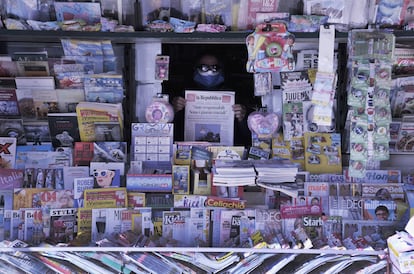 Un quiosquero sostiene una copia de 'La Reppublica' en un puesto en Livorno, Italia.