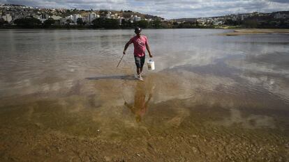 Un hombre camina por el lecho del r&iacute;o Doce.