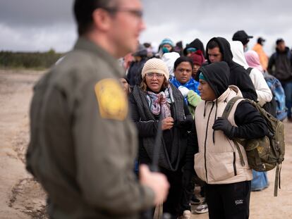 Migrantes peruanas escuchan las instrucciones de un agente de la Patrulla Fronteriza en la frontera de EE UU con México, en abril de 2024.