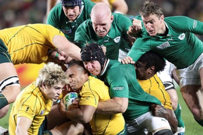 El irlandés Brian O'Driscoll para al australiano Will Genia durante la Copa del Mundo de rugby.