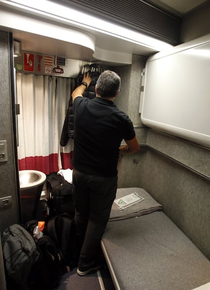 Uno de los viajeros coloca sus pertenencias en su camarote antes de la salida. Él va en un compartimento con dos literas, aunque solo una está desplegada. Su habitación cuenta con un aseo, una botella de agua, jabón y toalla para lavarse, y un pequeño neceser.