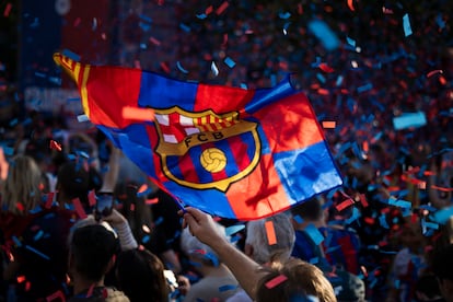 Un aficionado ondea una bandera con el escudo del Barcelona.