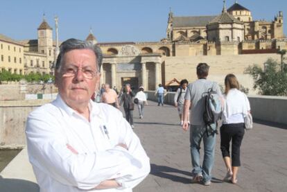 El arquitecto Juan Cuenca posa ante la puerta del Puente Romano, parte del área en torno al río Guadalquivir que ha rehabilitado.