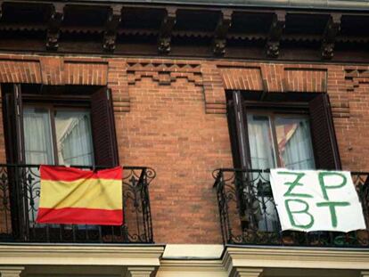 La bandera nacional junto a un mensaje contra el presidente del Gobierno en unos balcones de Madrid.