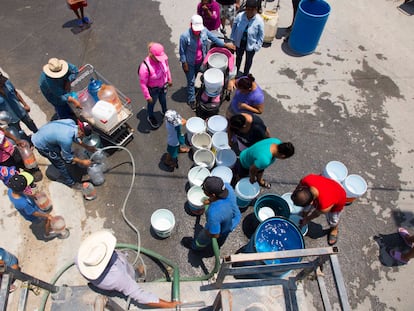 Los residentes de la colonia Villas de Alcali en Nuevo León, hacen fila para recoger agua limpia de un camión cisterna debido a la escasez de agua que afecta la zona metropolitana.