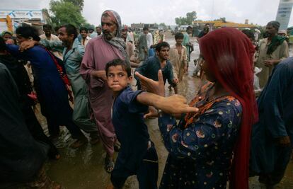 Un grupo de personas pelea por la ayuda distribuida por voluntarios en Shekarpur, Pakistán.
