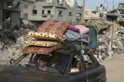 Una familia regresa a su hogar en coche, con algunas de sus pertenencias.