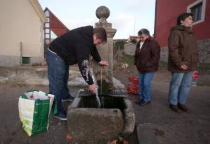 Un hombre recoge agua de la fuente de Valsaín (Segovia).
