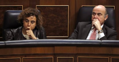 La ministra de Sanidad, Dolors Montserrat, y el ministro de Economía, Luis de Guindos, en el Congreso de los Diputados.