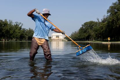 A worker clears algae and debris from the Lincoln Memorial Reflecting Pool on the National Mall, during a heat advisory in Washington, DC, USA, 28 July 2023.