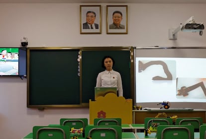 Una estudiante se encuentra bajo los retratos de los últimos líderes norcoreanos durante una conferencia en un colegio de formación docente, en una visita organizada por el gobierno para periodistas extranjeros en Pyongyang.