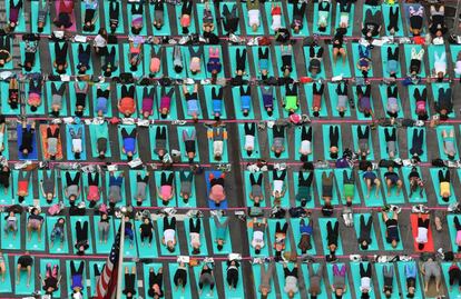 Un grupo numeroso de gente practica yoga en Times Square, en Nueva York (EE UU).