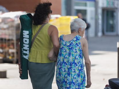 Una anciana camina con la ayuda de una mujer, en una imagen tomada el pasado julio en Madrid.