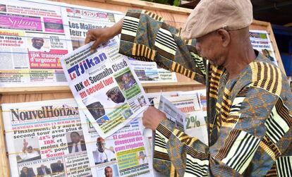 Un hombre mira un periódico en las calles de Bamako, en el que aparecen en primera página los dos contendientes.