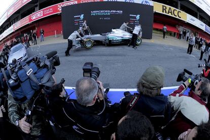 Varios mecánicos de la escudería Mercedes Petronas F1 empujan el W03 2012 antes de la presentación oficial del monoplaza de esta temporada.