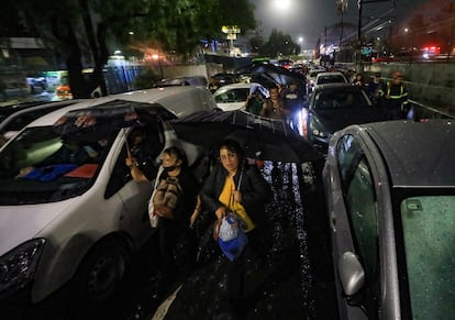 Usuarios de la Línea A del metro caminan desde la estación Guelatao hacia las inmediaciones del Estado de México debido a la suspensión del servicio por las inundaciones provocadas por las fuertes lluvias en la delegación Iztapalapa. 