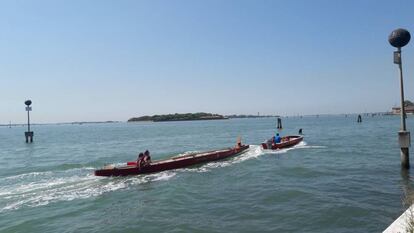 Una barca (con perro) pasa delante de la isla de San Giorgio Maggiore arrastrando a otra hacia la isla de la Giudecca, en Venecia.