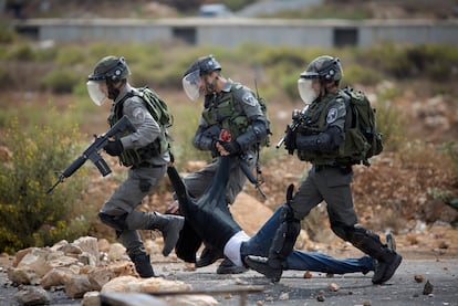 Soldados israelíes llevan a un palestino herido durante los enfrentamientos entre militares palestinos e israelíes cerca de Ramala.