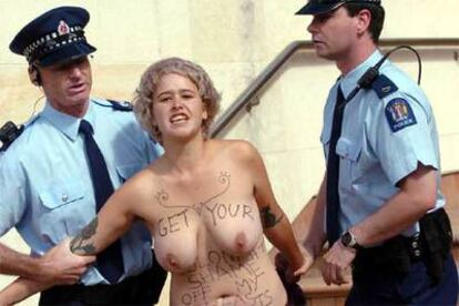 Una joven antimonárquica y anticolonialista protesta desnuda de cintura para arriba durante la visita del príncipe Carlos a Nueva Zelanda.