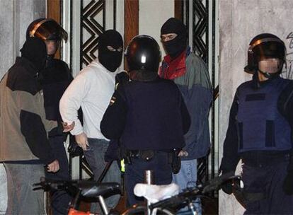 Agentes del Cuerpo Nacional de Policía trasladan el material incautado durante la operación contra la violencia callejera en San Sebastián.