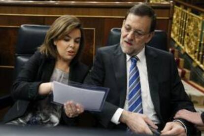 El presidente del Gobierno, Mariano Rajoy, y la vicepresidenta, Soraya Sáenz de Santamaría, conversan en sus escaños durante la sesión de control al Gobierno, que se celebra hoy en el Congreso de los Diputados.