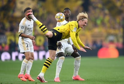 Julian Brandt corta un balón de forma acrobátic, ante  Camavinga  y Carvajal del Real Madrid.