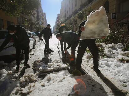 Vecinos retiraban con palas el hielo de la calzada en el barrio madrileño de Retiro el pasado día 12.