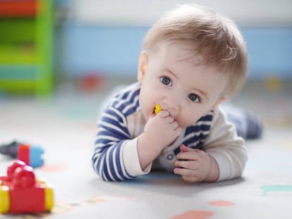 Un beb&eacute; juega con unos juguetes