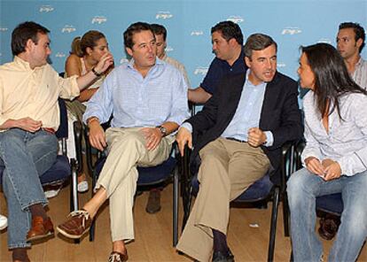 Ángel Acebes (tercero por la izquierda) junto a José María Michavila, entre militantes de Nuevas Generaciones.