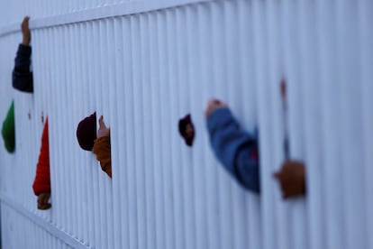 Familiares de los reclusos se asoman por los barrotes que rodean el centro penintenciario para poder divisar a sus parientes. 