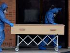 TOPSHOT - Workers move the coffin of a COVID-19 victim to be cremated at Serafin cemetery in Bogota, on July 4, 2020. - Latin America has the second most COVID-19 cases in the world with 2.73 million, head of Europe on 2.71 million but behind North America. Colombia, the fourth largest economy in the region, passed 100,000 cases this week. (Photo by Raul ARBOLEDA / AFP)