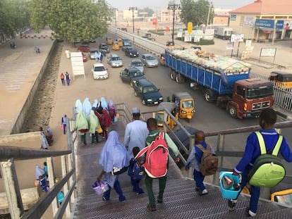 Varios escolares cruzan la principal entrada de la ciudad de Maiduguri.