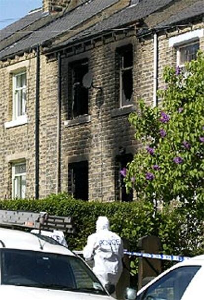 La policía examina la casa de Huddersfield después del incendio.